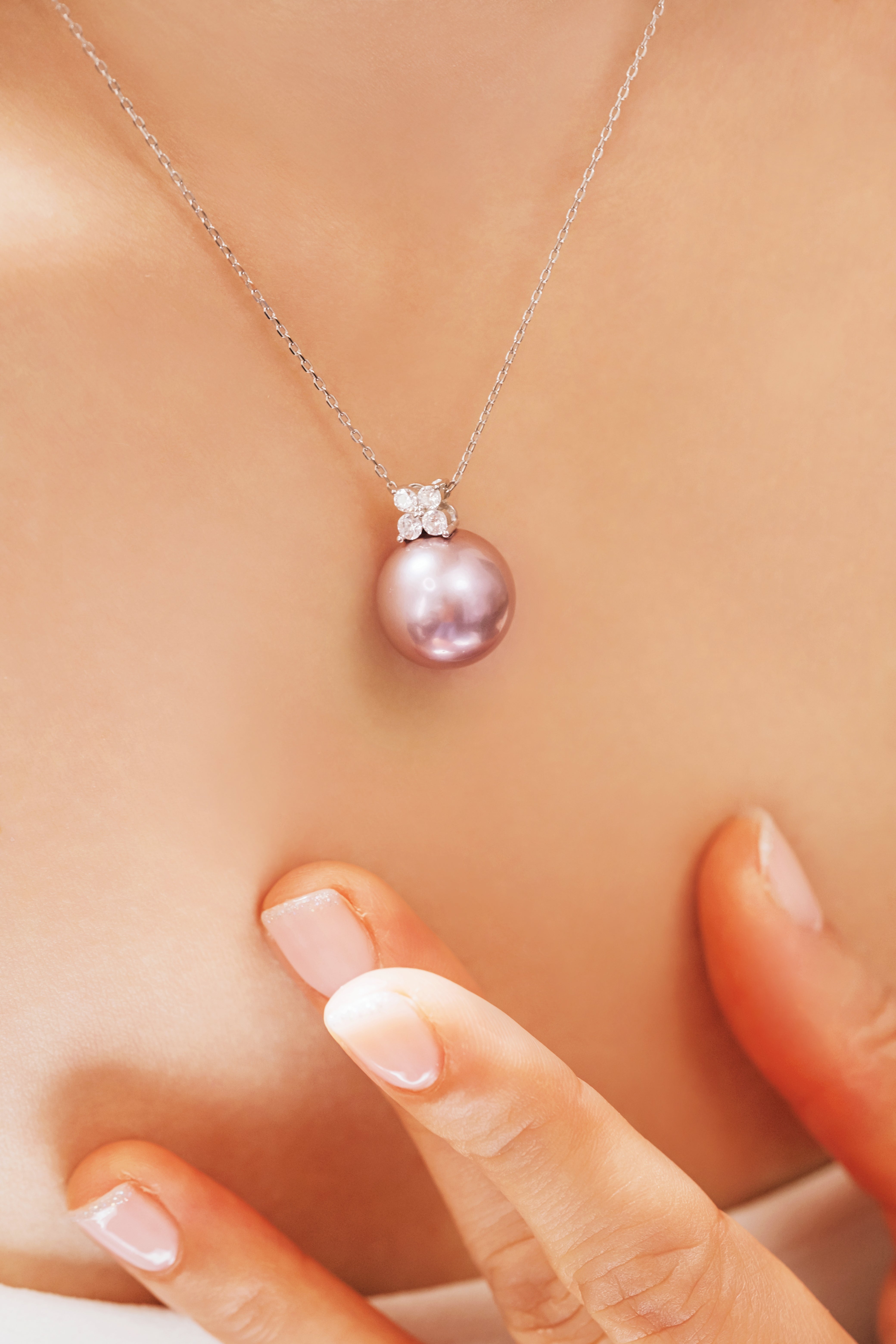 Pink pearl necklace with silver chain on a person's neck